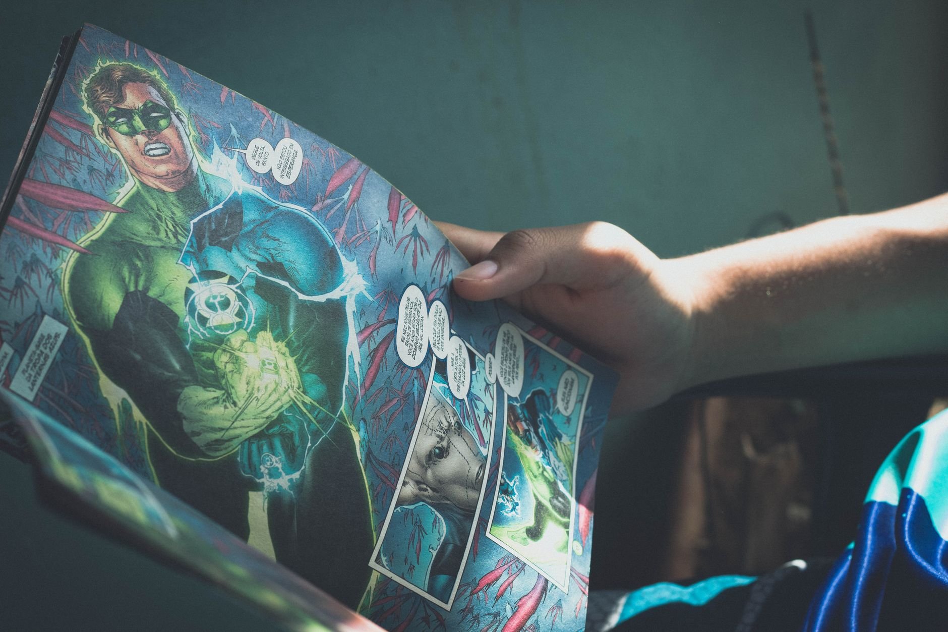 Person reading a comic book in atmospheric dim light
