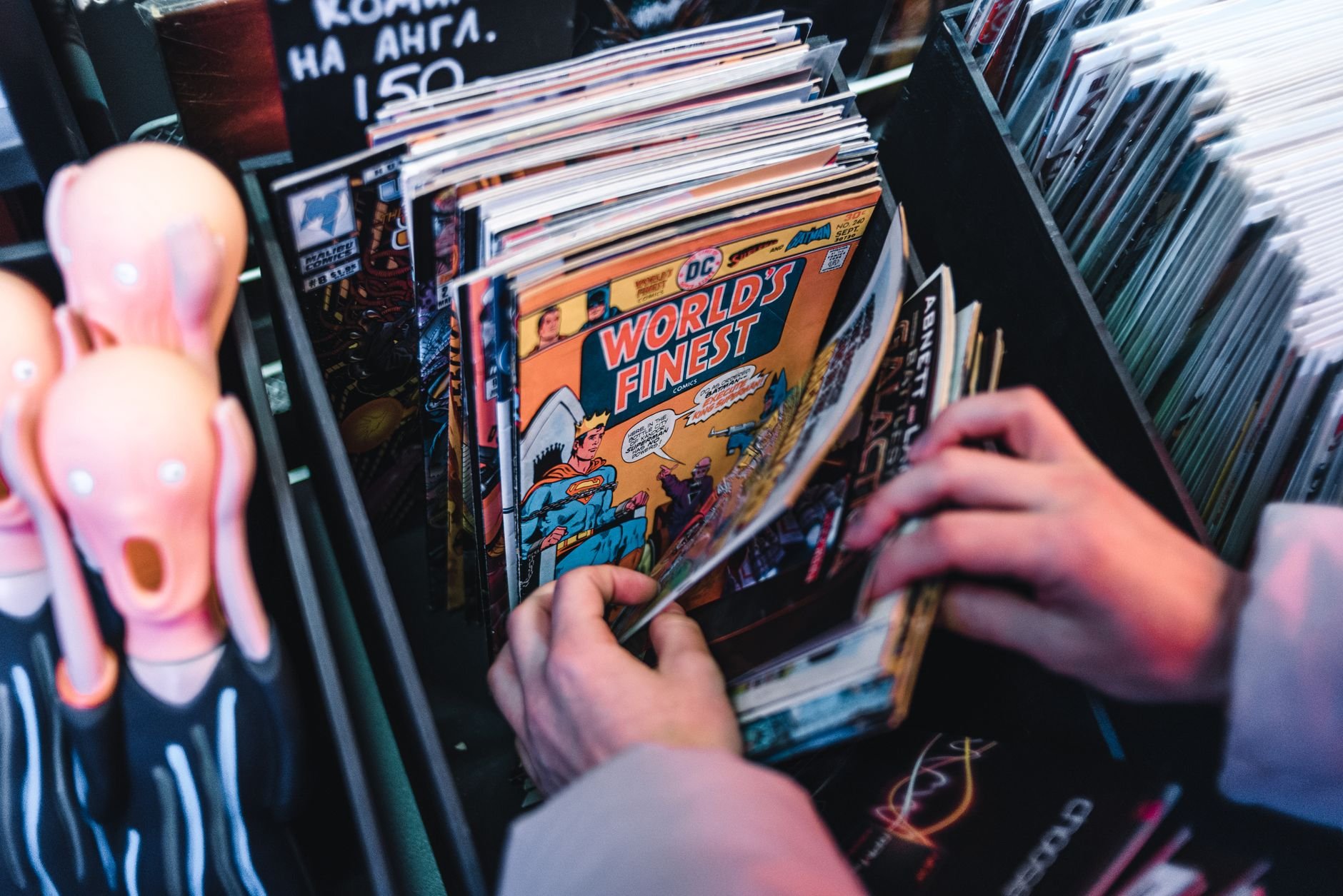 Hands sorting through vintage comic books